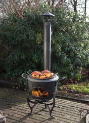 Poêle d'extérieur Globe-fire Volcano - en situation sur une terrasse pavée, avec ses tuyaux et son capuchon pare-pluie